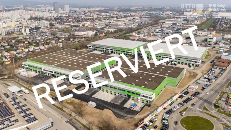 Luftaufnahme eines modernen Industriegebiets mit mehreren großen Lagerhallen und umliegender Infrastruktur.