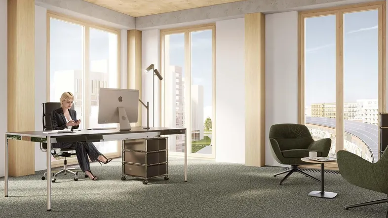 Modernes Büro mit großen Fenstern, Teppichboden und einer Arbeitsstation mit Blick auf die Stadt.