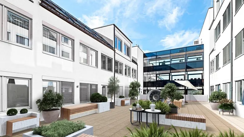 Attraktiver Innenhof mit modernen Sitzgelegenheiten und Pflanzen, umgeben von Bürogebäuden.