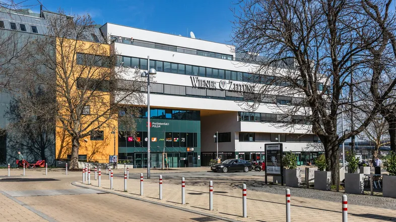 Modernes Bürogebäude mit markanter Architektur, großen Fenstern und der Aufschrift "Wiener Zeitung".