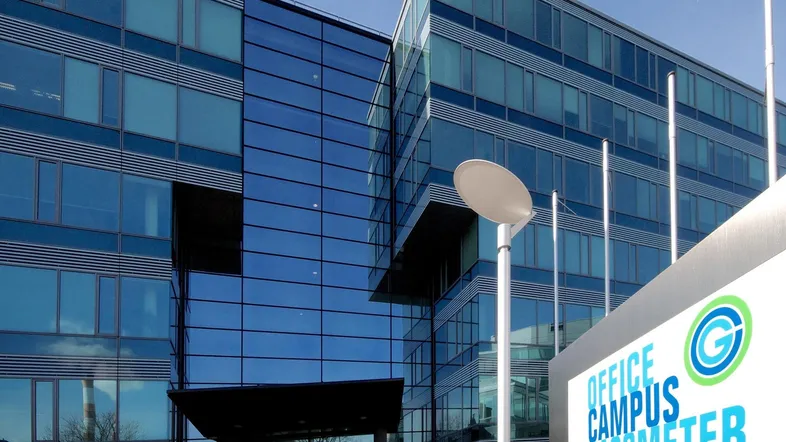 Modernes Bürogebäude mit glänzender Glasfassade und einem Hinweisschild für den Office Campus Gasometer.