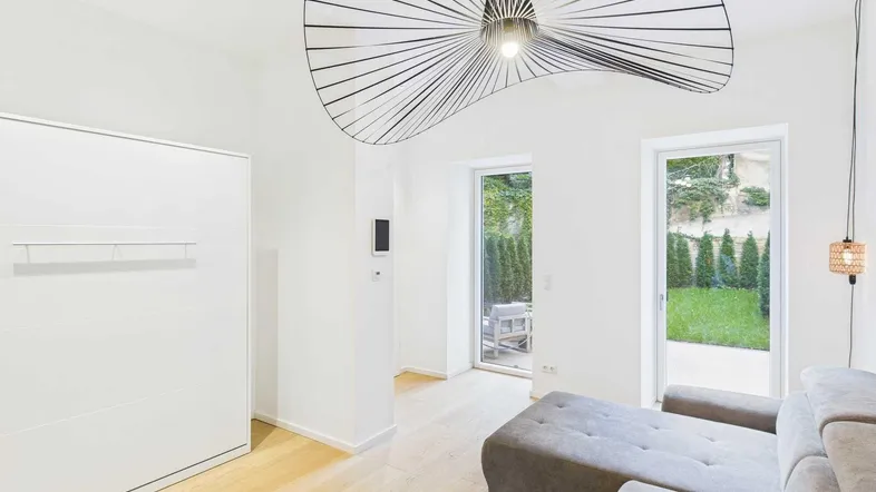 Heller Wohnraum mit modernem Design, Holzboden und direktem Zugang zum Gartenbereich.