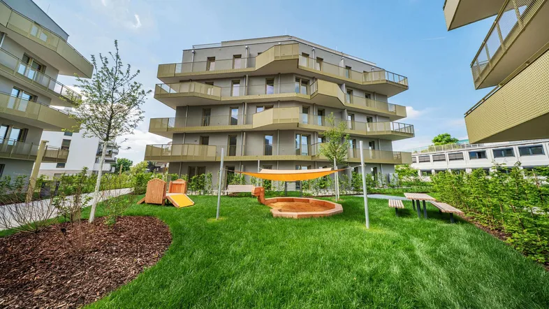 Moderne Wohnanlage mit ansprechenden Balkonen und einem gemeinschaftlichen Spielplatz im Grünen.