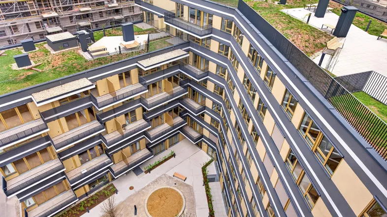 Luftaufnahme eines modernen Wohnkomplexes mit begrünten Dächern und einem Innenhof.