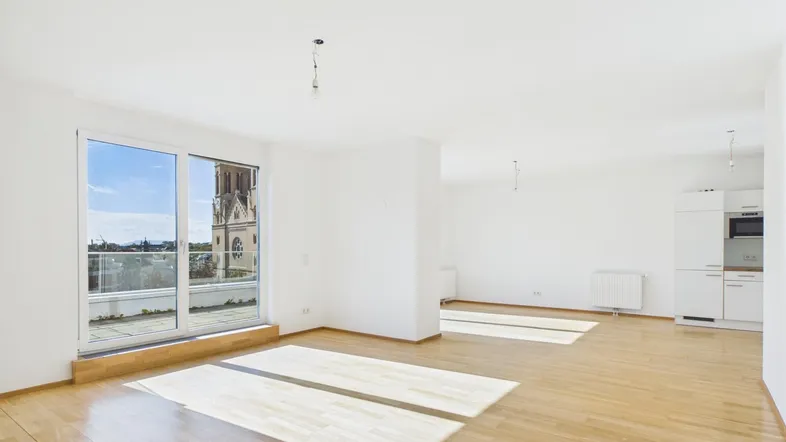 Helles, offenes Wohnzimmer mit Parkettboden, großen Fenstern und Blick auf die Stadtkirche.