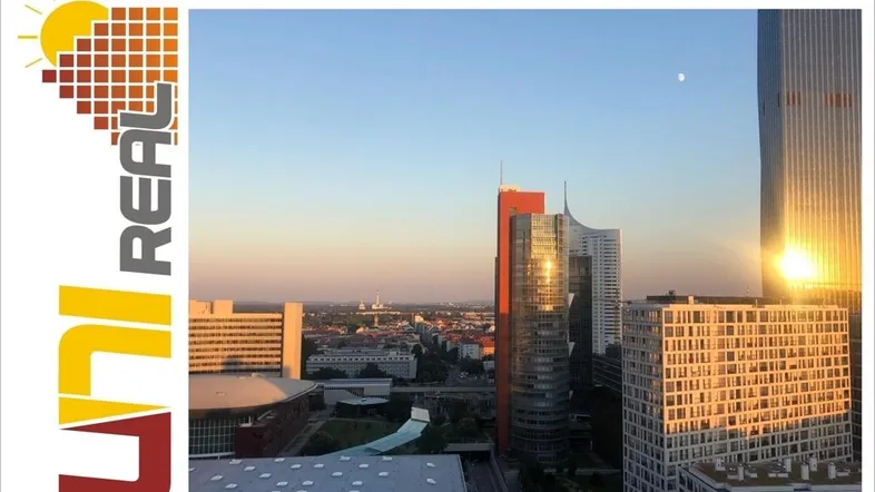 Panoramablick auf die Stadt bei Sonnenuntergang mit markanten Hochhäusern und einem leuchtenden Himmel.