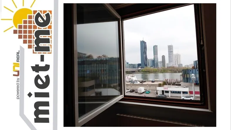 Blick aus dem Fenster auf die moderne Stadtlandschaft mit Hochhäusern und Fluss.