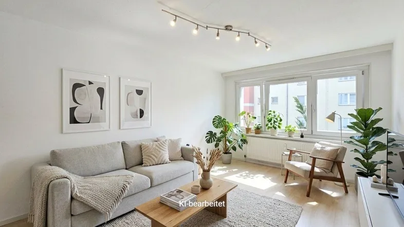 Helles Wohnzimmer mit beigem Sofa, Holztisch und vielen Pflanzen, modern eingerichtet.