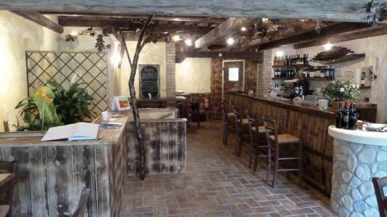 Rustikale Bar mit Holzbalken, Ziegelboden und gemütlicher Atmosphäre, ideal für Weinliebhaber.