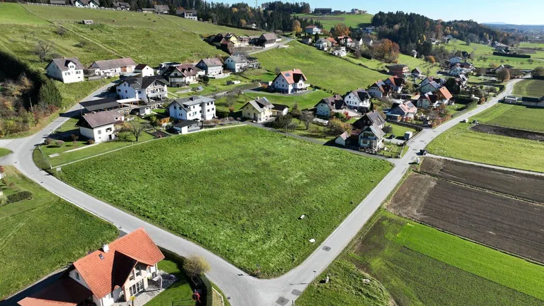 Luftaufnahme eines großen grünen Grundstücks, umgeben von Wohnhäusern und Straßen in ländlicher Umgebung.