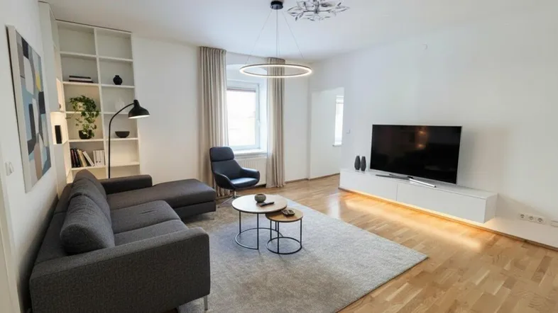 Modernes Wohnzimmer mit bequemer Couch, stilvoller Beleuchtung und Parkettboden, ideal zum Entspannen.