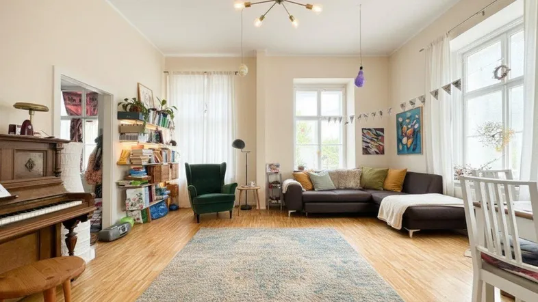 Helles und geräumiges Wohnzimmer mit Holzboden, gemütlicher Sitzecke und Klavier.
