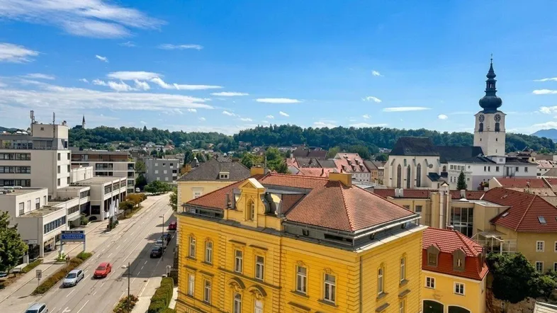 Panoramablick über die Stadt mit historischen Gebäuden und einer belebten Straße.