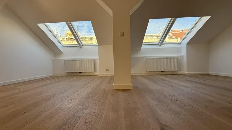 Helles Dachgeschosszimmer mit neuem Parkettboden und großen Dachfenstern, ideal für Wohnzwecke.