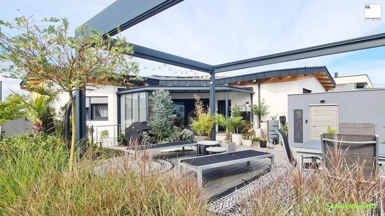 Große, modern gestaltete Terrasse mit Pergola, Sitzgelegenheiten und Blick auf das Haus.