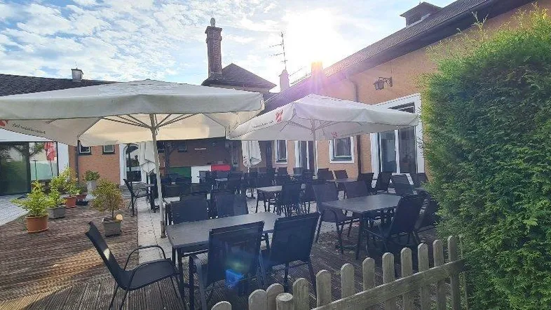 Geräumige Außenterrasse mit Sonnenschirmen und Sitzgelegenheiten, ideal für entspannte Stunden im Freien.