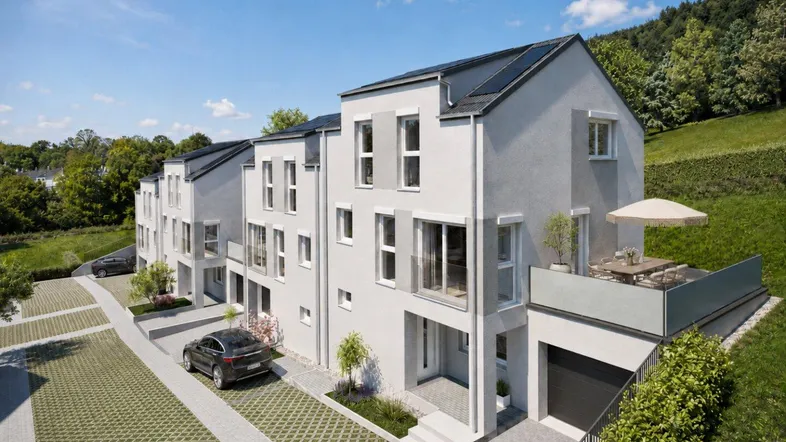 Moderne Doppelhäuser mit Solarpaneelen auf den Dächern, umgeben von grüner Landschaft und Hügeln.