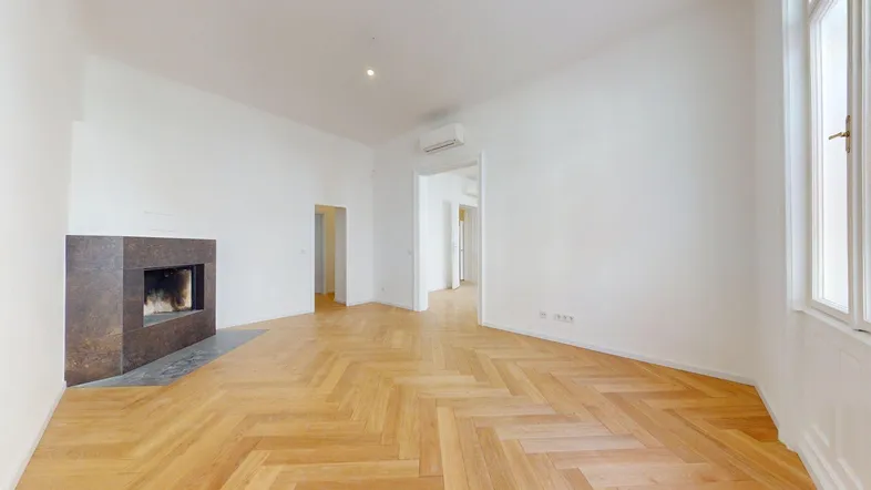 Helles Wohnzimmer mit modernem Kamin, Fischgrätparkett und Klimaanlage, das eine gemütliche Atmosphäre schafft.