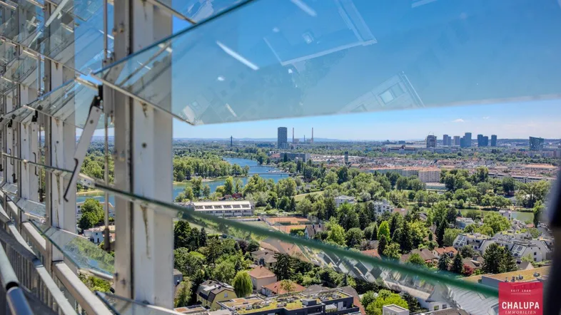 Ausblick durch die Glaslamellen auf die Stadt, den See und die weitläufigen Grünflächen.