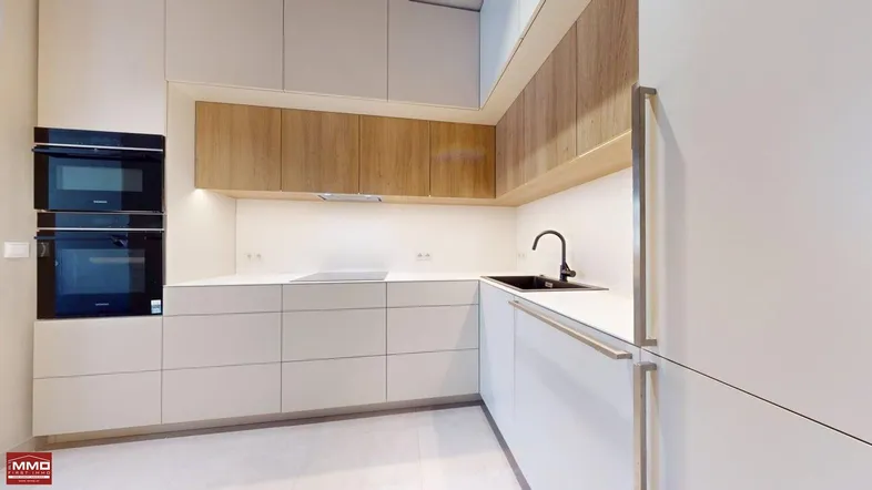 Elegante Küche mit doppelten Siemens-Öfen, weißen Fronten, Holzschränken und schwarzem Spülbecken.