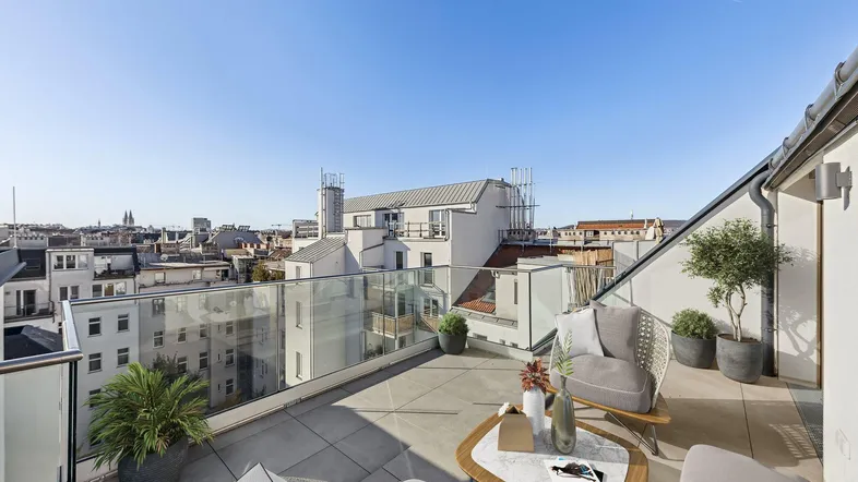 Geräumige Dachterrasse mit modernen Outdoor-Möbeln und weitem Blick über die Stadt.