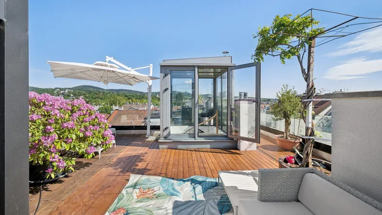 Geräumige Dachterrasse mit bequemen Sitzgelegenheiten, üppigen Pflanzen und weitem Blick über die Umgebung.