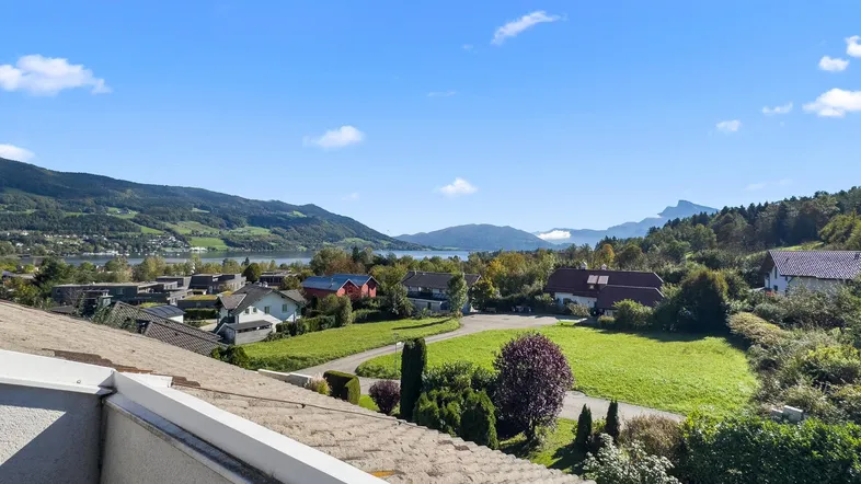 Panoramablick über den See und die umliegende Berglandschaft von einer erhöhten Position.