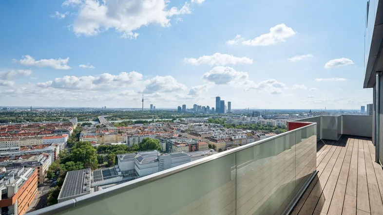 Geräumiger Balkon mit Holzboden und weitem Blick über die Stadt und die Donau.