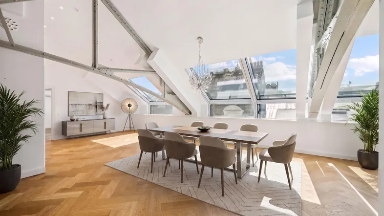 Helles Esszimmer mit Holzboden, großen Dachfenstern und modernem Esstisch.