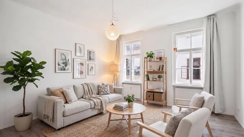 Helles Wohnzimmer mit modernem Mobiliar, Holzboden und großen Fenstern, ideal zum Entspannen.