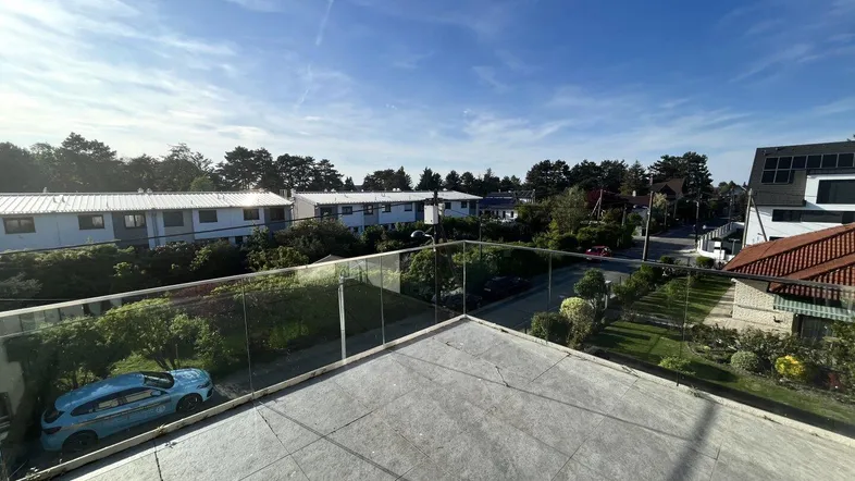 Große Dachterrasse mit Glasgeländer bietet einen weiten Blick über die umliegende Wohngegend.