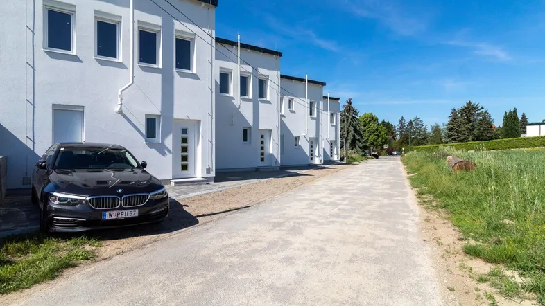 Reihenhäuser in moderner Architektur mit weißer Fassade und gepflegter Umgebung.