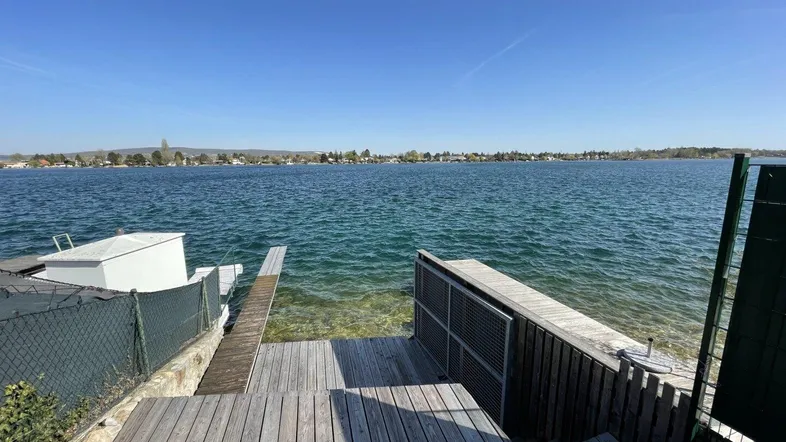 Holzsteg und Terrasse mit direktem Zugang zum See und weitem Seeblick.
