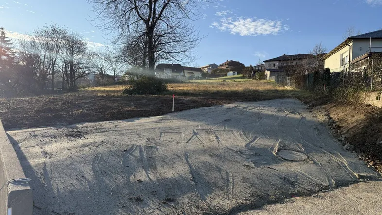 Vorbereiteter Grundstücksbereich mit Betonfläche und Blick auf die Umgebung.