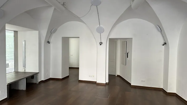 Geräumiger Innenraum mit beeindruckenden Gewölbedecken, weißen Wänden und dunklem Fliesenboden, der viel natürliches Licht erhält.