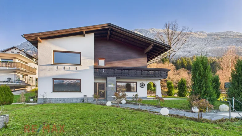 Großzügiges Einfamilienhaus mit traditionellen Holzelementen, Garten und Bergblick in sonniger Lage.