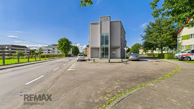 Ansicht des modernen Bürogebäudes von der Straße aus, umgeben von Grünflächen und Parkplätzen.