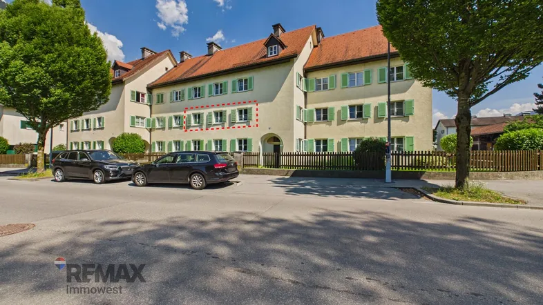 Traditionelles Mehrfamilienhaus mit grünen Fensterläden und Satteldach in sonniger Lage.