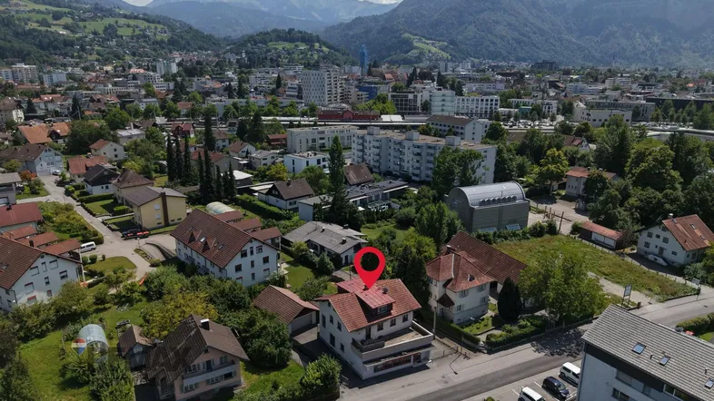 Luftaufnahme der Immobilie in einer städtischen Umgebung mit malerischem Bergblick.