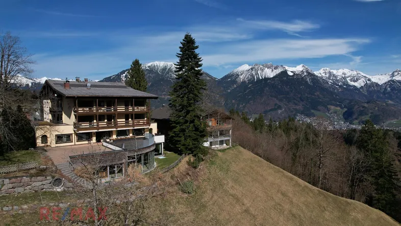 Großzügiges Anwesen in den Bergen mit mehreren Balkonen und atemberaubender Aussicht auf die schneebedeckten Gipfel.