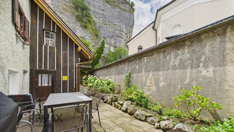 Gemütliche Terrasse mit Sitzgelegenheiten und Blick auf die beeindruckende Felswand.