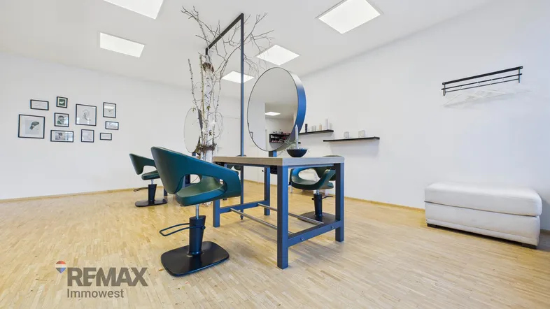 Heller und moderner Friseursalon mit mehreren Arbeitsplätzen, großen Spiegeln und Holzfußboden.