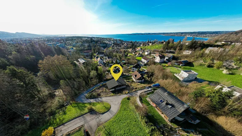 Luftaufnahme der Umgebung mit See und Bergen, die das Grundstück hervorhebt.
