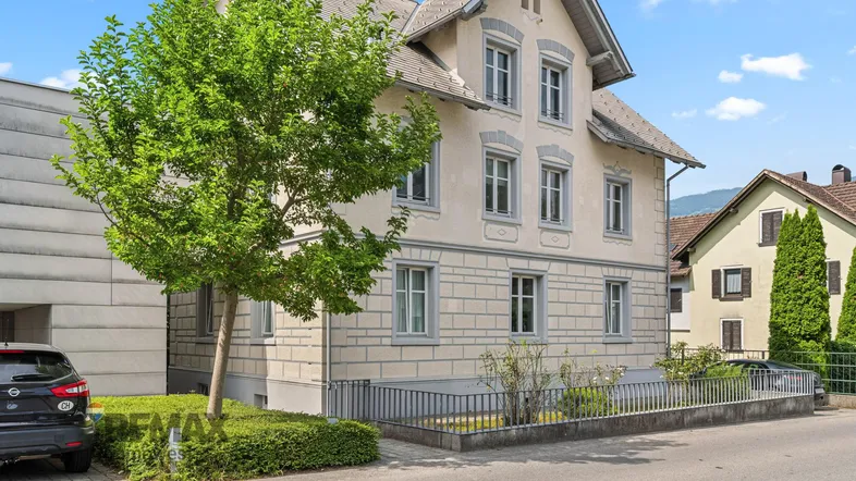 Klassisches Mehrfamilienhaus mit heller Fassade und gepflegtem Vorgarten in ruhiger Wohngegend.