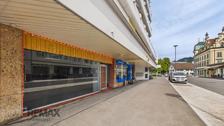 Ansicht der Geschäftsfassade mit großen Schaufenstern und Holzelementen an einer belebten Straße.