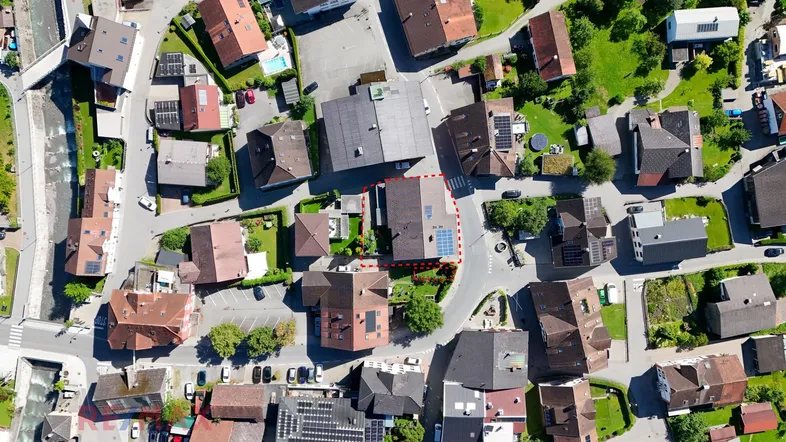 Luftaufnahme des Wohngebiets mit umliegenden Häusern, Straßen und viel Grünfläche.