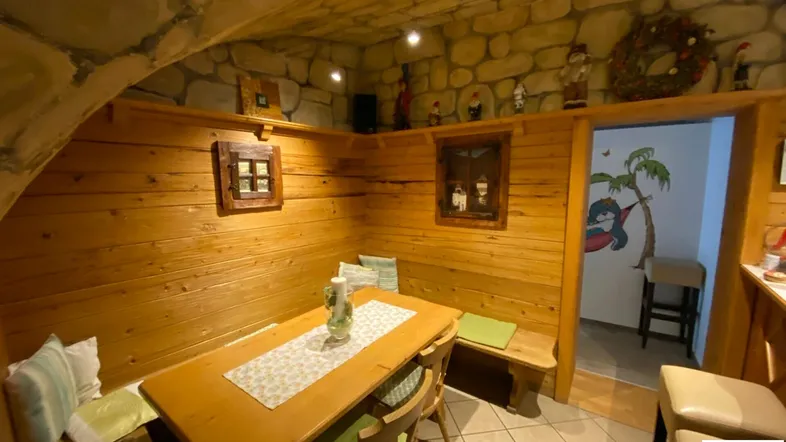 Rustikaler Essbereich mit Holzvertäfelung, Steindecke und traditioneller Dekoration.