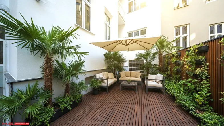 Sonnige Terrasse mit Holzbelag, Palmen und bequemen Gartenmöbeln in einem Innenhof.