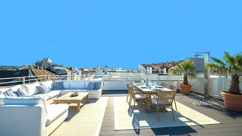 Geräumige Dachterrasse mit bequemen Loungemöbeln, Esstisch und Palmen, ideal für Entspannung im Freien.