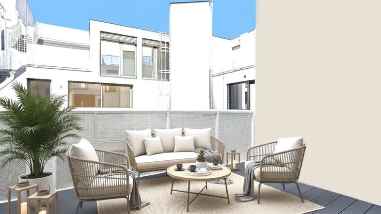 Gemütliche möblierte Terrasse mit Sitzgelegenheiten und Pflanzen, umgeben von Gebäuden.